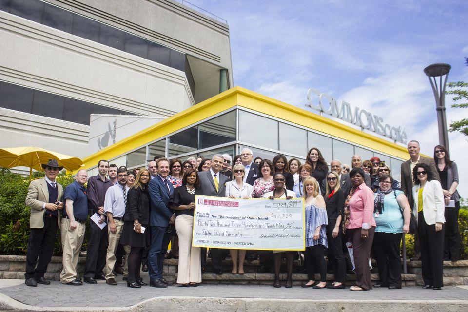 Group photo of people holding a large check