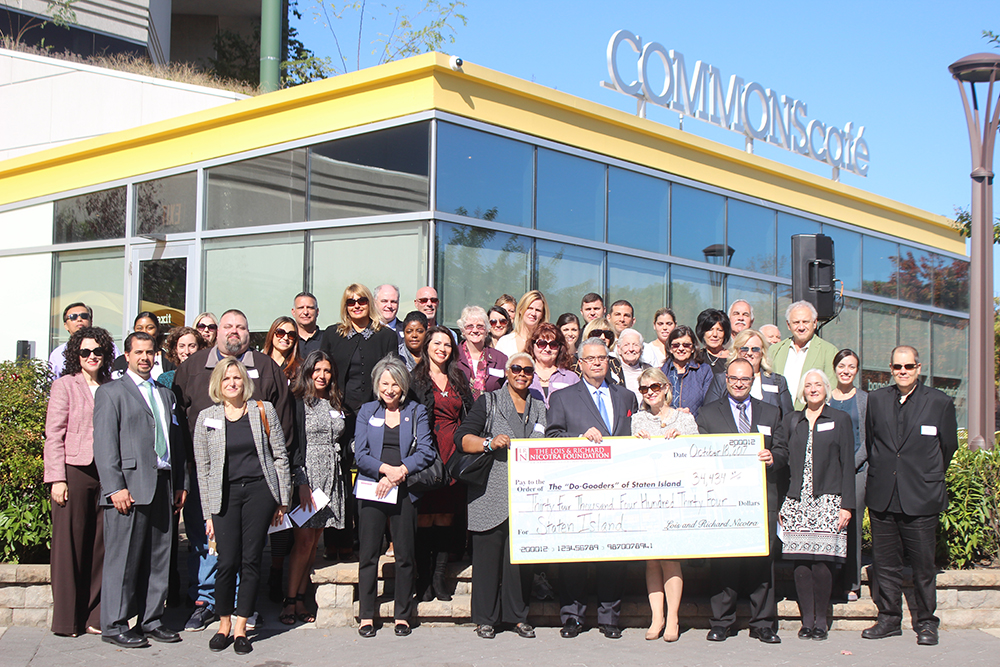 Group photo of people holding a large check
